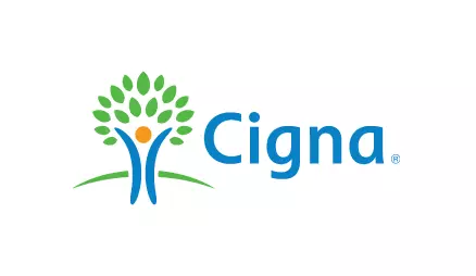 The image shows a logo with the text Cigna in blue, featuring a stylized tree with leaves and roots, set against a light background.