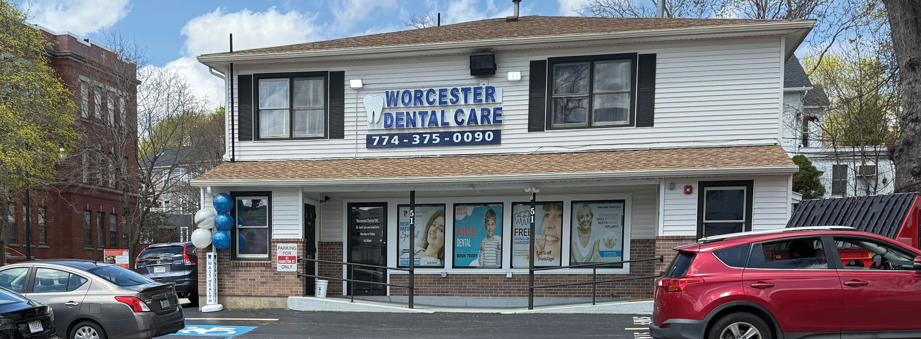 The image shows a building with a sign that reads WORCESTER DENTAL and a parking lot with cars parked outside of the building.
